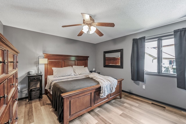 11847 Meadow Curv, Lindstrom, MN 55045 - bedroom with light wood-style flooring, a textured ceiling, and a ceiling fan