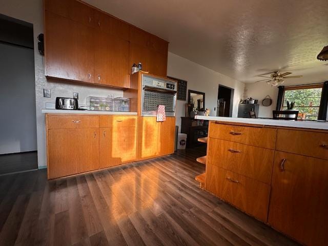 3507 Salo Rd, Waasa Twp, MN 55732 - kitchen with stainless steel oven, dark wood finished floors, light countertops, and ceiling fan