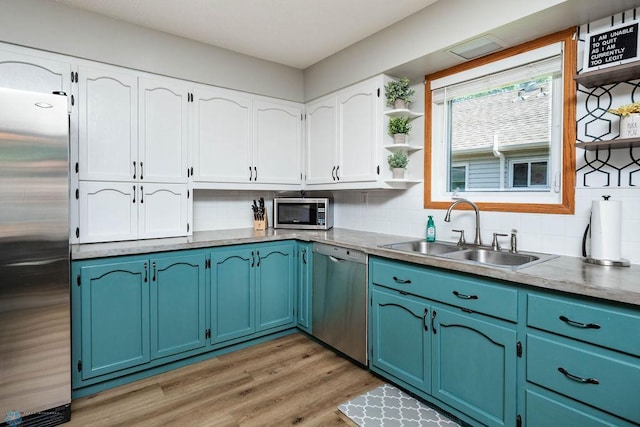 105 5th Ave W, West Fargo, ND 58078 - kitchen with stainless steel appliances, open shelves, blue cabinetry, backsplash, and white cabinets