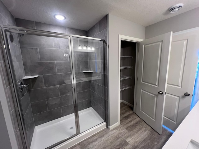 2488 Jacamar Ave NE, Saint Michael, MN 55376 - bathroom featuring a textured ceiling, wood finished floors, and a shower stall