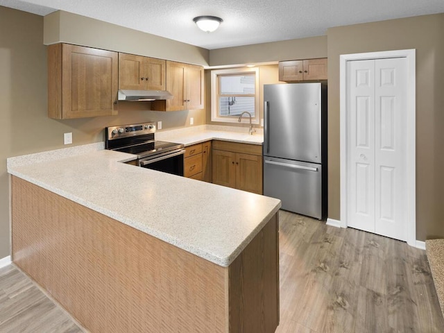 26161 8th St W, Zimmerman, MN 55398 - kitchen with stainless steel appliances, under cabinet range hood, light countertops, a peninsula, and a textured ceiling