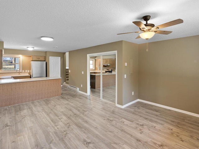 26161 8th St W, Zimmerman, MN 55398 - unfurnished living room with a ceiling fan, light wood-style floors, and a textured ceiling