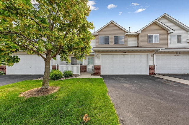 3014 Pebble Beach Dr, Faribault, MN 55021 - multi unit property with brick siding, asphalt driveway, a front yard, and an attached garage