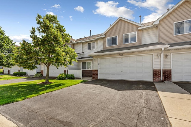 3014 Pebble Beach Dr, Faribault, MN 55021 - townhome / multi-family property featuring brick siding, asphalt driveway, a garage, and a front yard