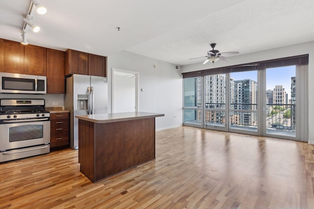 929 Portland Ave Unit 1002, Minneapolis, MN 55404 - kitchen with appliances with stainless steel finishes, light wood-style floors, ceiling fan, track lighting, and a center island