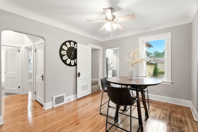 4529 17th Ave S, Minneapolis, MN 55407 - dining space featuring arched walkways, ceiling fan, and light wood-style floors