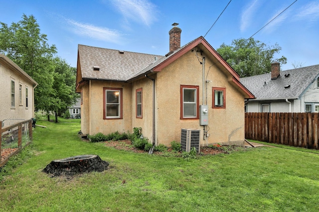4529 17th Ave S, Minneapolis, MN 55407 - back of house with stucco siding, a chimney, and roof with shingles