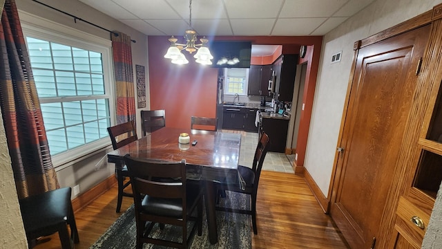 717 2nd Ave SW, Pipestone, MN 56164 - dining room featuring a drop ceiling, a chandelier, and wood finished floors