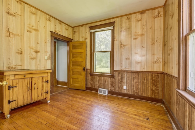 18320 Rum River Blvd NW, Oak Grove, MN 55303 - unfurnished room featuring light wood-style flooring, wood walls, and crown molding