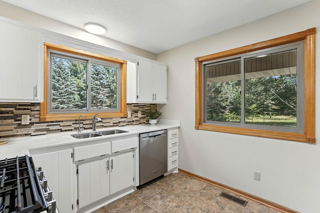 14226 310th Ave, Princeton, MN 55371 - kitchen featuring stainless steel dishwasher, backsplash, light countertops, white cabinets, and range with gas stovetop