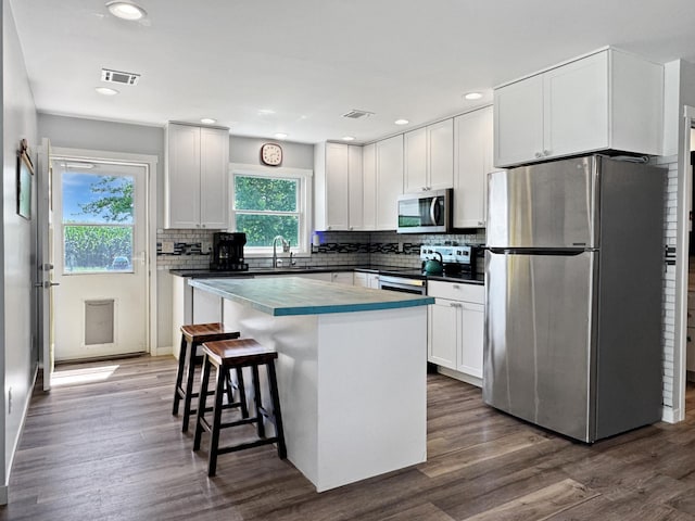 34 Shady Rest Rd, Lake Sarah Twp, MN 56132 - kitchen with stainless steel appliances, backsplash, white cabinetry, a breakfast bar area, and recessed lighting