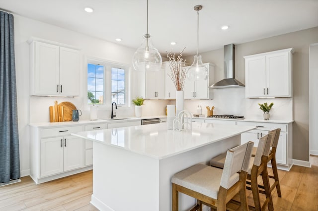 7945 Jade Ln, Victoria, MN 55386 - kitchen with wall chimney range hood, light countertops, a center island with sink, light wood-style flooring, and recessed lighting