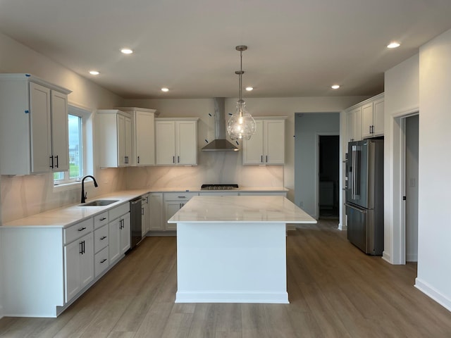7945 Jade Ln, Victoria, MN 55386 - kitchen with appliances with stainless steel finishes, wall chimney exhaust hood, light wood-type flooring, a kitchen island, and recessed lighting