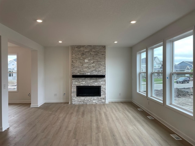 7945 Jade Ln, Victoria, MN 55386 - unfurnished living room with wood finished floors, a stone fireplace, and recessed lighting