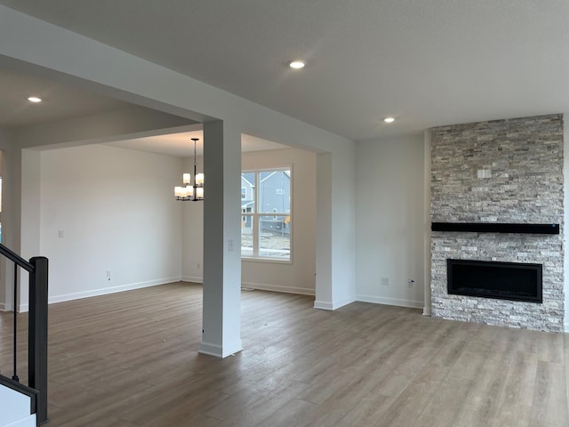 7945 Jade Ln, Victoria, MN 55386 - unfurnished living room featuring dark wood-style floors, a chandelier, a fireplace, stairway, and recessed lighting