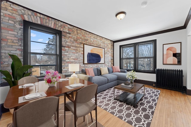 2218 Nicollet Ave Unit 22, Minneapolis, MN 55404 - living area featuring radiator, crown molding, wood finished floors, and brick wall