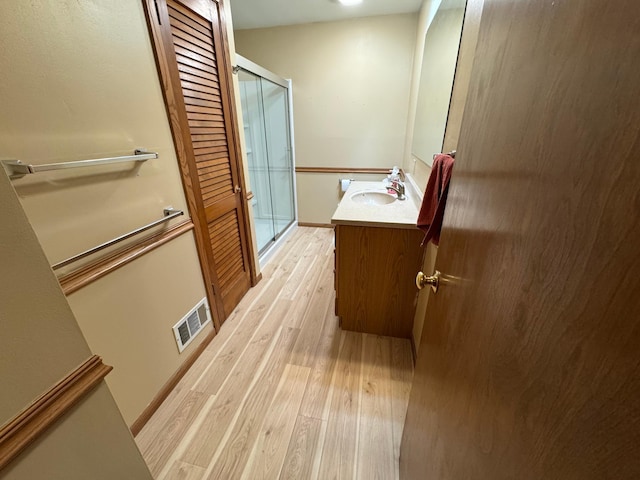 1204 Garflield Ave, Albert Lea, MN 56007 - bathroom featuring vanity, wood finished floors, and a stall shower