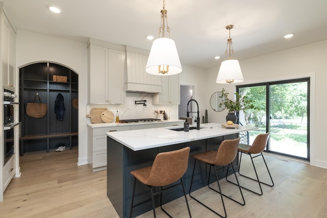 625 Ivy Falls Ave, Mendota Heights, MN 55118 - kitchen featuring stainless steel gas cooktop, light wood-type flooring, recessed lighting, light stone countertops, and decorative backsplash