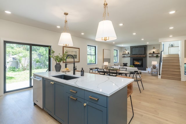 625 Ivy Falls Ave, Mendota Heights, MN 55118 - kitchen featuring a fireplace, an island with sink, light wood-style floors, pendant lighting, and open floor plan