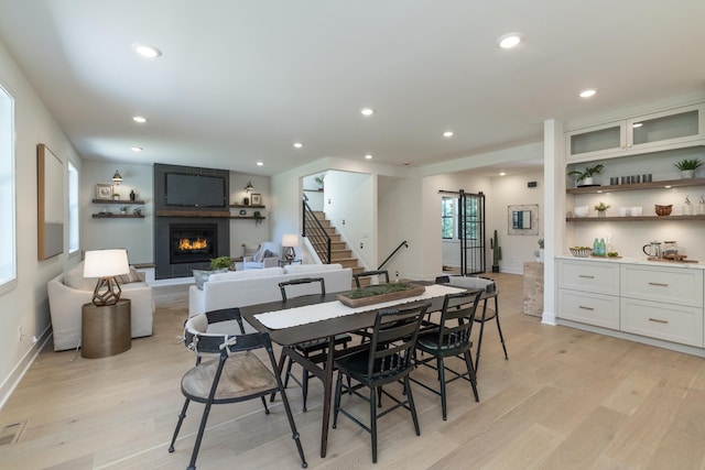 625 Ivy Falls Ave, Mendota Heights, MN 55118 - dining room featuring light wood-style flooring, a large fireplace, a barn door, stairs, and recessed lighting