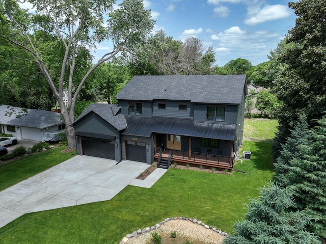 625 Ivy Falls Ave, Mendota Heights, MN 55118 - view of front of home featuring an attached garage, covered porch, driveway, a front lawn, and a metal roof
