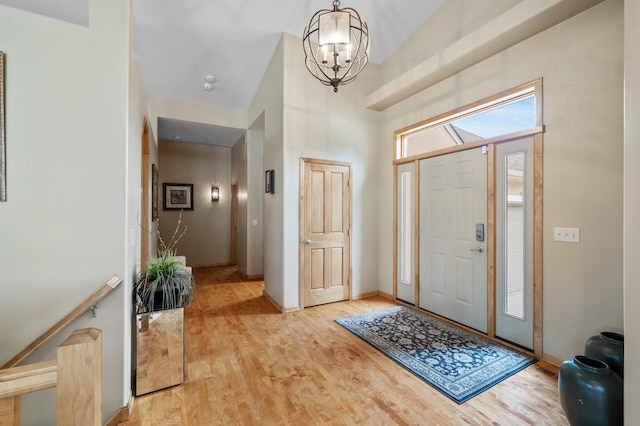 11880 Dunkirk Cir NE, Blaine, MN 55449 - entrance foyer featuring a chandelier, light wood finished floors, and a high ceiling
