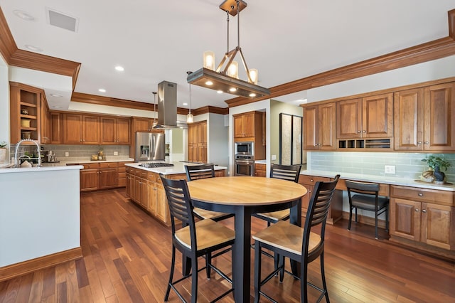 7471 260th St, Wyoming, MN 55092 - kitchen with appliances with stainless steel finishes, island range hood, ornamental molding, brown cabinets, and light countertops