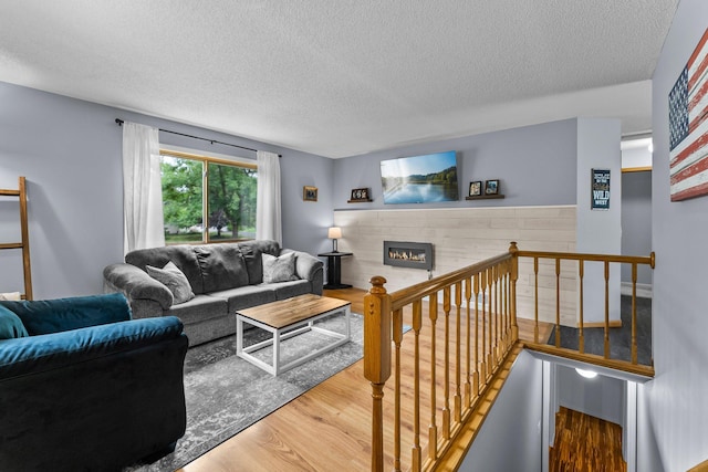 6071 Red Fox Run, North Branch, MN 55056 - living area featuring wood finished floors, a textured ceiling, and a tiled fireplace