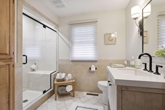 9525 Shore Trl N, Forest Lake, MN 55025 - full bath with vanity, tile walls, a shower stall, tile patterned floors, and wainscoting