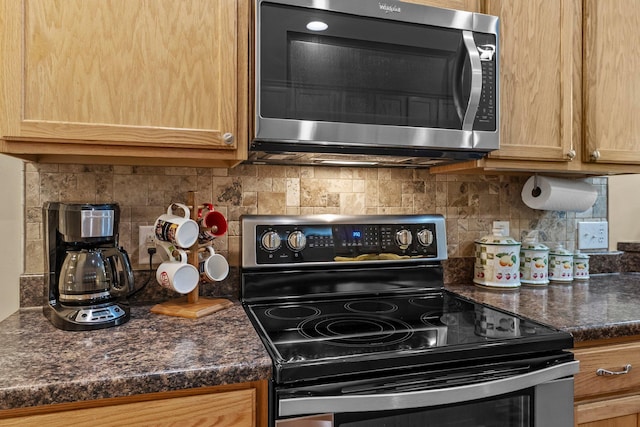 15618 Emerald Dr N Unit 2, Hugo, MN 55038 - kitchen with stainless steel microwave, range with electric stovetop, dark countertops, and tasteful backsplash