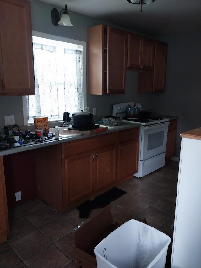 206 20th St S, Benson, MN 56215 - kitchen featuring electric stove, tile patterned flooring, and brown cabinetry