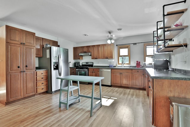75309 Twin Oaks Rd, Bremen Twp, MN 55735 - kitchen with appliances with stainless steel finishes, light wood finished floors, dark countertops, brown cabinetry, and under cabinet range hood