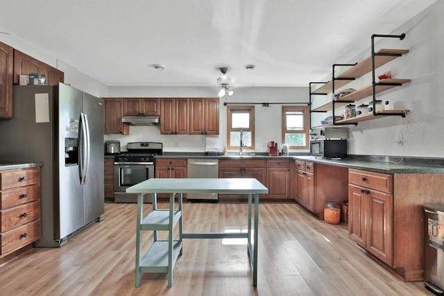 75309 Twin Oaks Rd, Bremen Twp, MN 55735 - kitchen featuring appliances with stainless steel finishes, under cabinet range hood, light wood-style flooring, dark countertops, and a ceiling fan