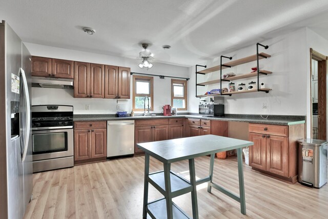 75309 Twin Oaks Rd, Bremen Twp, MN 55735 - kitchen with stainless steel appliances, under cabinet range hood, light wood-style floors, and dark countertops
