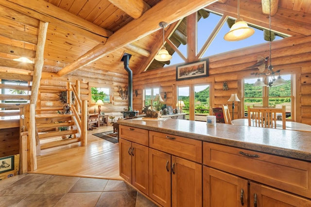 30453 County Road 19, Wiscoy Twp, MN 55971 - kitchen featuring a wood stove, a wooden ceiling with exposed beams, rustic walls, high vaulted ceiling, and hanging light fixtures
