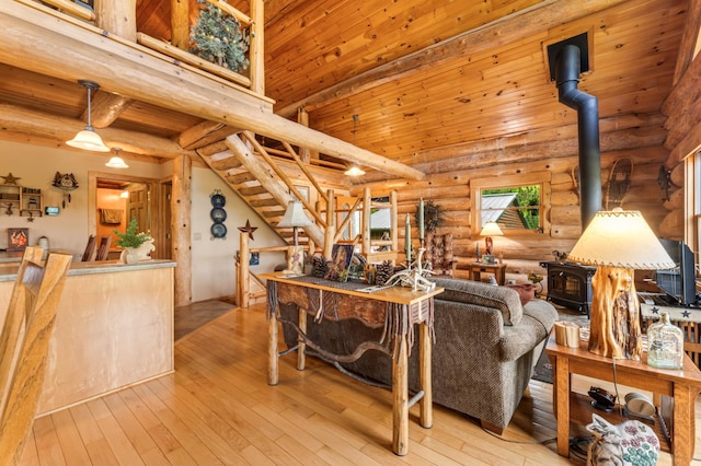 30453 County Road 19, Wiscoy Twp, MN 55971 - living room featuring a wood stove, rustic walls, wood-type flooring, wood ceiling, and stairs