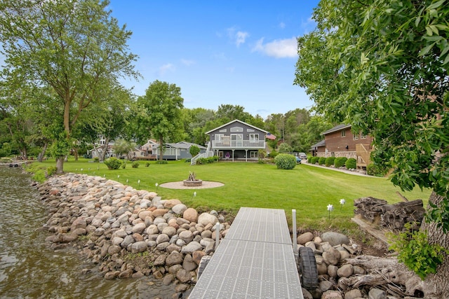 50945 Almond Ave, Nessel Twp, MN 55080 - view of green lawn featuring a fire pit, a deck with water view, and view of wooded area