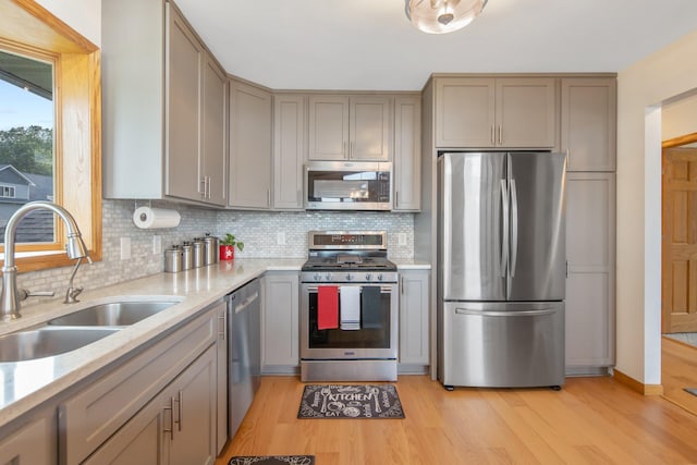50945 Almond Ave, Nessel Twp, MN 55080 - kitchen featuring stainless steel appliances, gray cabinetry, backsplash, and light wood finished floors