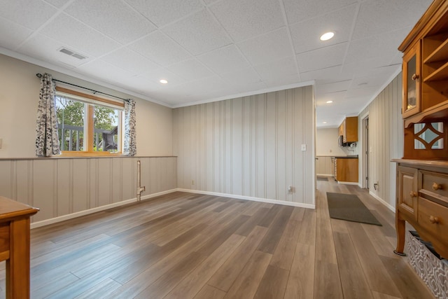 50945 Almond Ave, Nessel Twp, MN 55080 - unfurnished room with wood finished floors, crown molding, wainscoting, recessed lighting, and a decorative wall