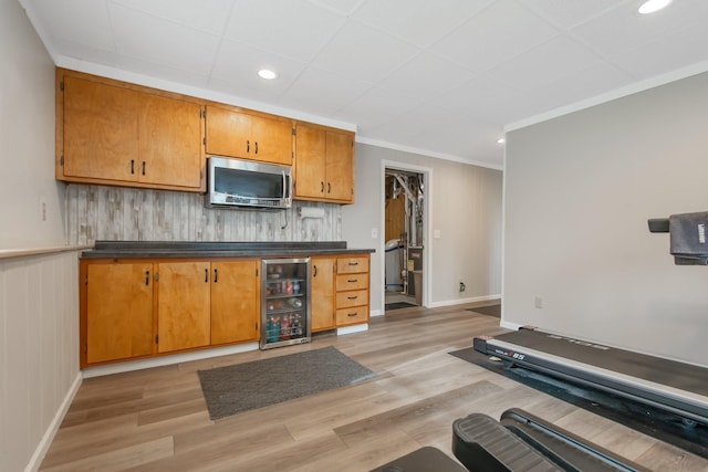 50945 Almond Ave, Nessel Twp, MN 55080 - kitchen with stainless steel microwave, wine cooler, dark countertops, light wood finished floors, and crown molding