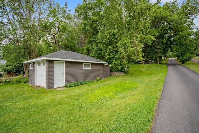 50945 Almond Ave, Nessel Twp, MN 55080 - exterior space featuring a lawn, an outbuilding, a shingled roof, and view of scattered trees