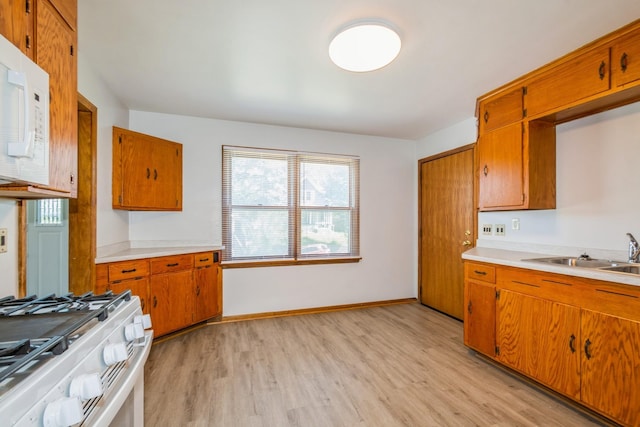 3654 Lyndale Ave N, Minneapolis, MN 55412 - kitchen featuring white appliances, brown cabinets, and light wood-style flooring