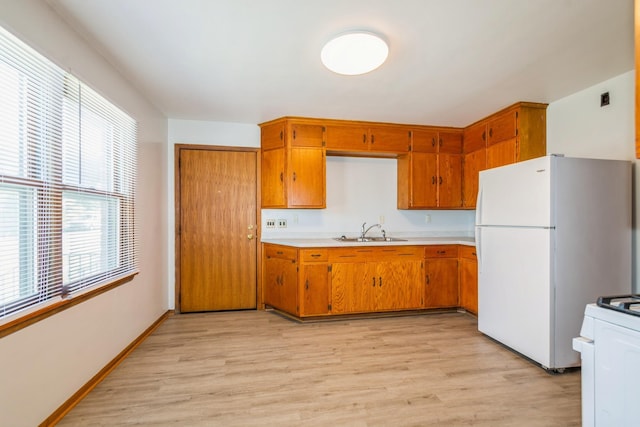 3654 Lyndale Ave N, Minneapolis, MN 55412 - kitchen with light countertops, light wood finished floors, white appliances, and brown cabinets