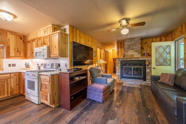 40936 Yost Rd, Emily, MN 56447 - kitchen with white appliances, open floor plan, wooden walls, ceiling fan, and a fireplace