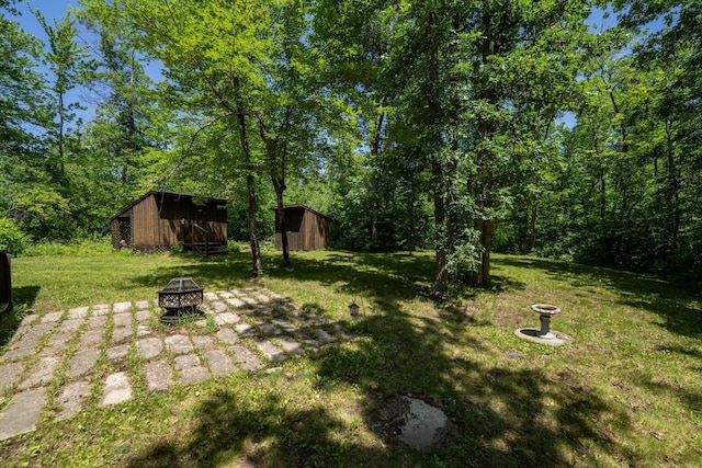 40936 Yost Rd, Emily, MN 56447 - view of grassy yard with a fire pit and a storage shed