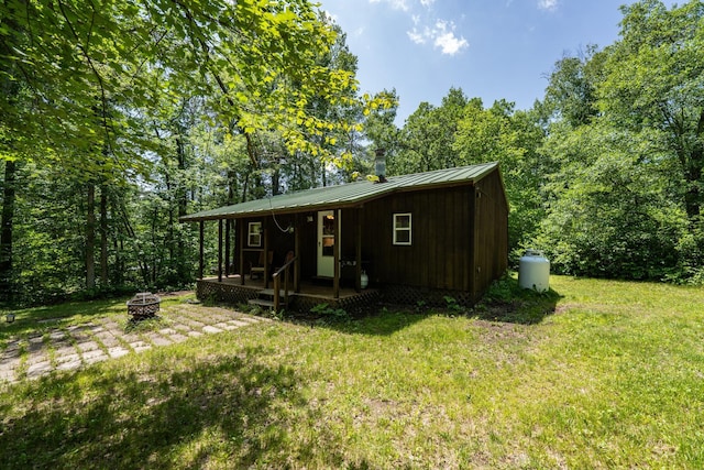 40936 Yost Rd, Emily, MN 56447 - view of front of house featuring a fire pit, a standing seam roof, a front yard, and a metal roof