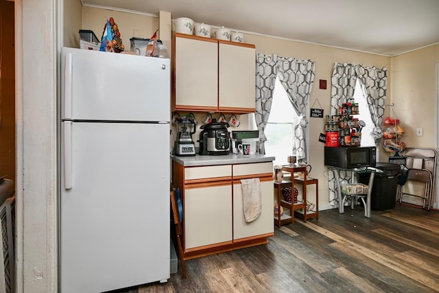 159 King St, Winona, MN 55987 - kitchen featuring freestanding refrigerator, dark wood-type flooring, black microwave, crown molding, and light countertops