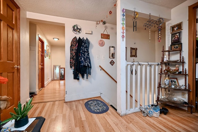 159 King St, Winona, MN 55987 - corridor featuring light wood-style floors, an upstairs landing, and a textured ceiling