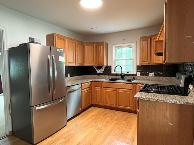 1304 3rd St NW, Austin, MN 55912 - kitchen featuring stainless steel appliances, light wood-type flooring, and backsplash