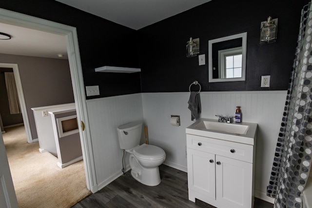 1304 3rd St NW, Austin, MN 55912 - full bath with a wainscoted wall, vanity, wood finished floors, and a shower with curtain